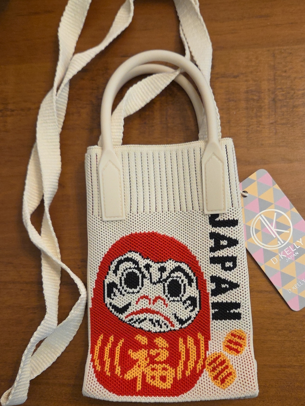 Cream Knit Crossbody Bag with Daruma Motif by D.Kelly